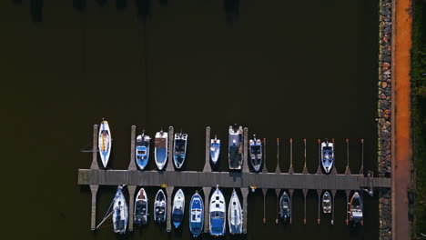 Top-shot-of-small-boats-docked-on-a-small-pier-or-dock-in-Helsinki,-Finland,-camera-moving-forward
