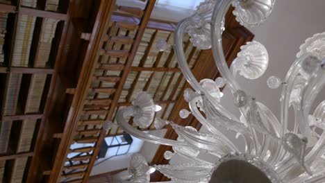 Biblioteca-Teresiana-Mantova-|-Crystal-chandelier-in-a-room-with-an-old-wooden-shelf