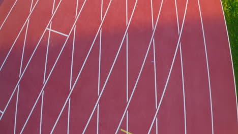 Outdoor-empty-red-athletic-track,-aerial-top-down-view