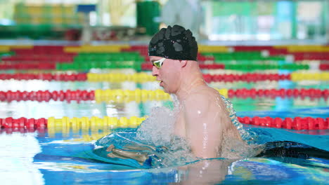 Male-swimmer-during-breaststroke-swimming-training,-side-slow-motion-shot