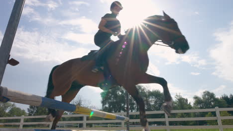 Female-jockey-on-horse-leaping-over-hurdles,-in-the-open-manege,-handheld-shot