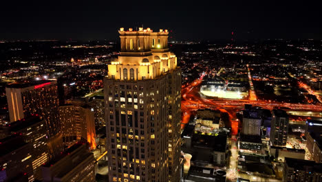 Toma-De-Drone-Acercándose-Que-Muestra-Una-Torre-De-Noventa-Y-Un-Peachtree-Por-La-Noche-En-La-Ciudad-De-Atlanta,-Georgia