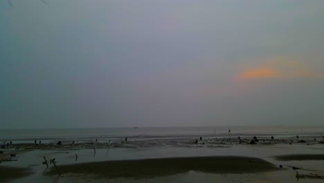 Dämmerung-über-Dem-Meeresstrand-Von-Kuakata-Bei-Ebbe-Mit-Einem-Einsamen-Mann,-Der-An-Der-Schlammigen-Küste-In-Bangladesch-Spaziert