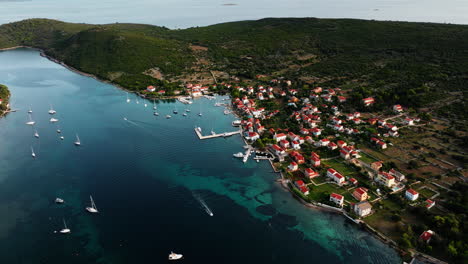 Panoramic-establishing-view-above-Ilovik-island-Croatia-as-boat-exits-channels-out-to-sea