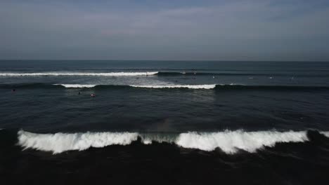 Aerial-push-forward-shot-surfer-on-ocean-wait-on-wave-Bali
