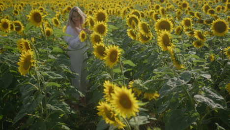 Beautiful-happy-woman-at-sunflower-field-in-sunset---nature-preservation-concept