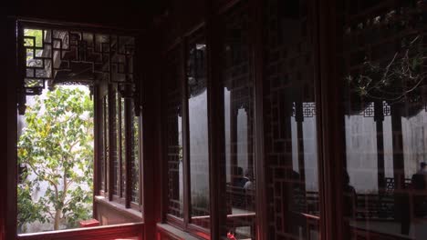 Pavillon-Und-Kleines-Reihenhaus-Im-Yuyuang-Garten-In-Shanghai,-China-Mit-Menschen,-Die-Sich-Im-Glasfenster-Spiegeln