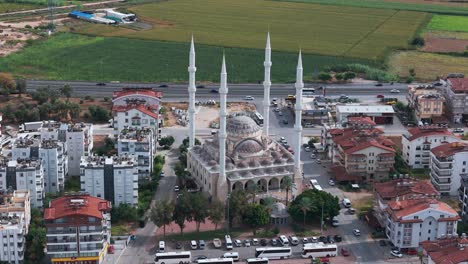 Aerial-view-circling-the-Manavgat-mosque-in-the-Antalya-region-with-fields-in-the-background,-Turkey