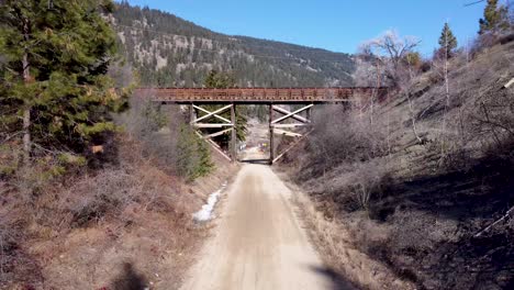 El-Dron-Del-Sendero-Ferroviario-De-Okanagan-Vuela-Bajo-Un-Viejo-Puente-Peatonal-De-Caballete-De-Madera