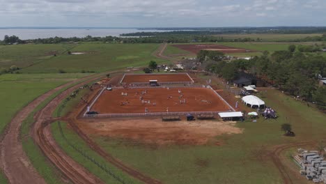 Aerial-View-of-Thrilling-Horse-jumping-event,-Horse-riders-performing-stunts-on-the-horse-jumping-barn