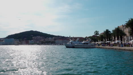 Boote-Liegen-An-Der-Promenade-In-Split,-Während-Im-Hintergrund-Ein-Flugzeug-Fliegt