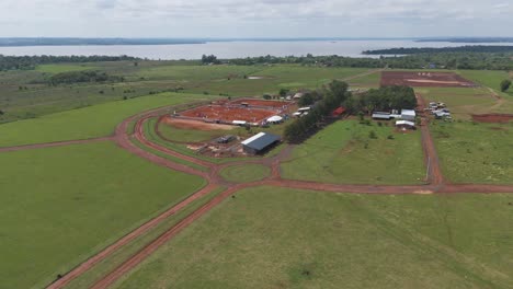 Vista-Aérea-Del-Establo-De-Caballos-Situado-Junto-Al-Cuerpo-De-Agua.