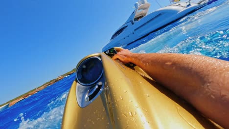POV-of-a-diver-skimming-the-surface-near-a-yacht-using-an-aquatic-propulsion-system