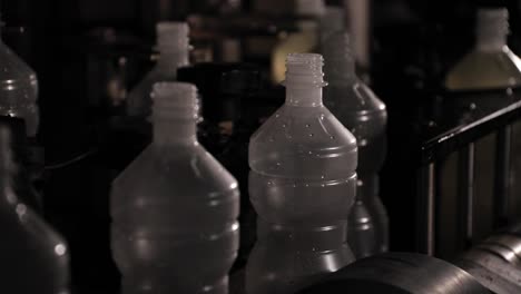Empty-plastic-bottles-travel-along-a-conveyor-belt-at-a-vinegar-factory,-awaiting-the-process-of-being-filled-with-fresh-vinegar