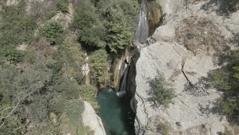 Drohnenaufnahme-Von-Oben-Nach-Unten-Des-Bogova-Wasserfalls-Im-Sommer-In-Albanien-In-Den-Bergen-An-Einem-Sonnigen-Tag-Ohne-Menschen-Und-Klares,-Blaues-Wasser