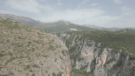 Drohnenaufnahme-In-Der-Nähe-Des-Gjipe-Strandes-In-Albanien,-In-Der-Nähe-Der-Berge-Und-Des-Meeres-An-Einem-Sonnigen-Und-Hellen-Tag-Und-Grüner-Natur-Zwischen-Den-Felsen,-Spaltriss,-Massiver,-Gespaltener-Baumstamm