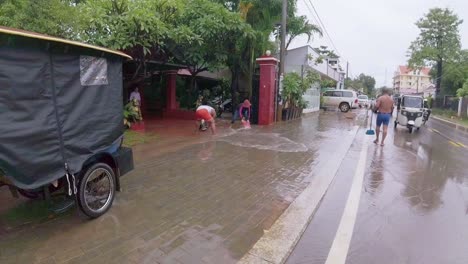 Menschen-Schöpfen-Nach-Sintflutartigen-Regenfällen-Im-Touristenzentrum-Von-Siem-Reap,-Kambodscha,-Wasser-Aus-Ihren-Häusern