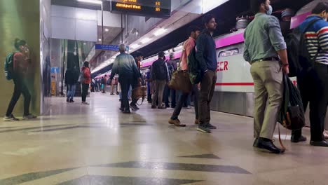 Vista-De-La-Estación-De-Metro-Con-La-Llegada-Del-Metro-Y-El-Pasajero-Caminando-Desde-Diferentes-ángulos.-El-Vídeo-Se-Toma-En-Janakpuri,-Oeste-De-Delhi,-India,-El-4-De-Enero-De-2023.