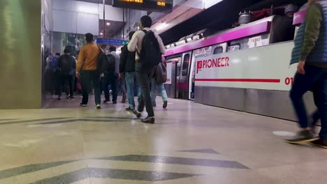 Vista-De-La-Estación-De-Metro-Con-La-Llegada-Del-Metro-Y-El-Pasajero-Caminando-Desde-Diferentes-ángulos.-El-Vídeo-Se-Toma-En-Janakpuri,-Oeste-De-Delhi,-India,-El-4-De-Enero-De-2023.