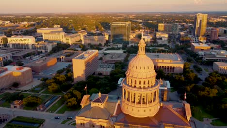 Downtown-Austin,-Texas-State-Capital-Building,-Aerial-Drone-Shot-Circling-Dome-with-Goddess-of-Liberty-Statue-on-Top-with-Views-of-The-University-of-Texas-at-Austin-Campus,-Skyline-at-Sunset-in-4K