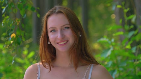 Beautiful-friendly-red-haired-girl-smiling-gently-in-camera-close-up-portrait