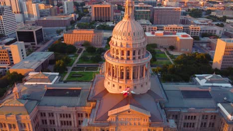 Centro-De-Austin,-Edificio-De-La-Capital-Del-Estado-De-Texas,-Disparo-Aéreo-De-Un-Dron-Sobrevolando-La-Estatua-De-La-Diosa-De-La-Libertad-En-La-Parte-Superior-Con-Vistas-De-La-Universidad-De-Texas-En-El-Horizonte-Del-Campus-De-Austin-Al-Atardecer-En-4k