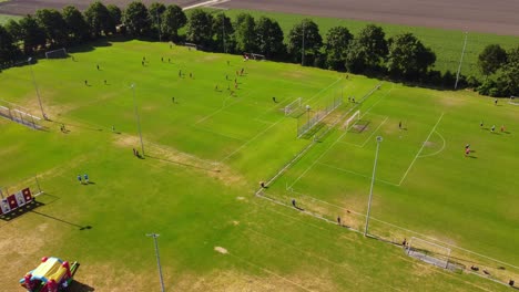 Dos-Campos-De-Fútbol-Con-Jugadores-Jugando-Un-Partido-De-Fútbol-En-Una-Tarde-Soleada.