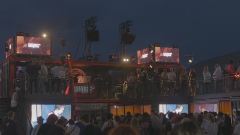 Eine-Riesige-Menschenmenge-Tanzt-Auf-Einem-Hip-Hop-Festival-Mit-Einer-Lichtshow-Im-Hintergrund