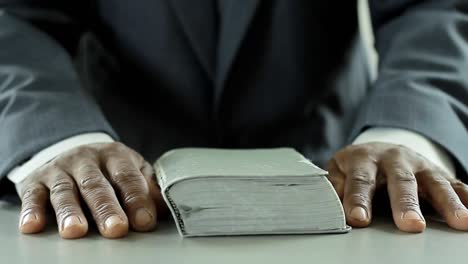 Hombre-Negro-Orando-A-Dios-Con-La-Biblia-En-Las-Manos-Hombre-Caribeño-Orando-Con-Fondo-Con-Gente-Video-De-Archivo-Metraje-De-Archivo