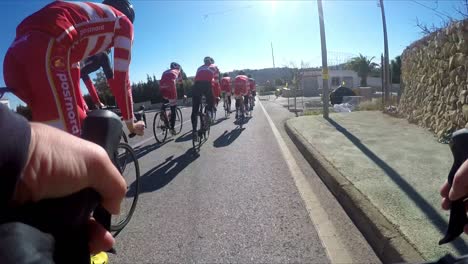 Radtraining-Calpe,-Spanien,-Eine-Gruppe-Von-Radprofis-Fährt-An-Einem-Wintermorgen-An-Einer-Kleinen-Stadt-Vorbei