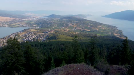 Hiker-walks-up-at-Viewpoint-in-Canadian-Mountains-overlooking-Okanagan-Lake-and-Lakecountry-in-British-Columbia's-Interior-Region