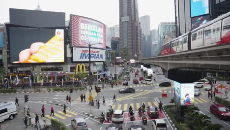 Daytime-shot-with-train-passing-and-Traffic-at-Kuala-Lumpur's-busy-Jalan-Sultan-Ismail-and-Jalan-Bukit-Bintang-Intersection,-Malaysia