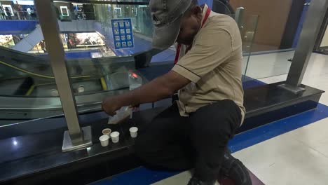 Nearby-scene,-a-security-guard-in-a-super-mall-is-drinking-tea-during-relax-time
