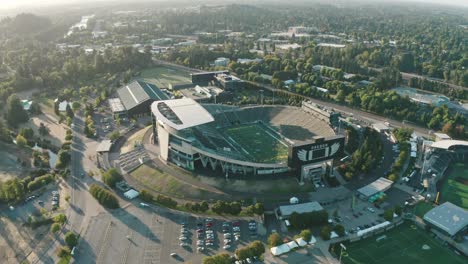 A-drone-rotates-over-the-horizon-above-Autzen-Stadium-in-Eugene,-Oregon