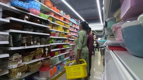 A-woman-with-her-husband-is-shopping-for-household-plastic-items-at-a-shopping-mall