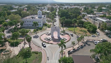 Arc-of-triumph-and-city-hall-at-San-Juan-de-la-Maguana-with-urbanscape-in-background,-Dominican-Republic