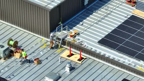 Male-workers-on-industrial-rooftop-installing-solar-panels