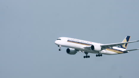 Singapore-Airlines-A350-making-a-landing-with-wheels-down-and-landing-lights-on-with-blue-sky-background-at-Suvarnabhumi-Airport-in-Bangkok,-Thailand