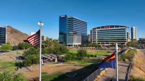 Bandera-Americana-Y-Bandera-De-Arizona-Ondeando-Frente-A-Tempe,-Paisaje-Urbano-De-Az