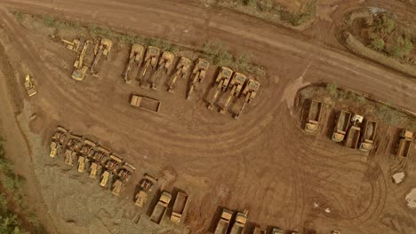 A-fleet-of-dusty-Trucks-and-Diggers-lined-up-in-the-dirt-at-a-Nickel-Mine-in-Taganito,-Philippines