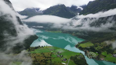Oldevatnet-Glacier-Lake-and-Mountain-Valley-covered-in-clouds-in-Norway,-Loen,-Vestland---Aerial-Circling