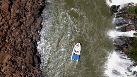 Top-view-Semirigid-Boat-Navigating-by-the-Waters-of-Moconá-Falls,-Uruguay-River