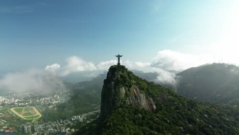 Toma-Cinematográfica-De-Un-Dron-Que-Muestra-La-Estatua-Del-Cristo-Redentor-En-La-Cima-De-Una-Colina-Con-El-Paisaje-Urbano-De-Río-De-Janeiro-En-El-Valle,-Brasil