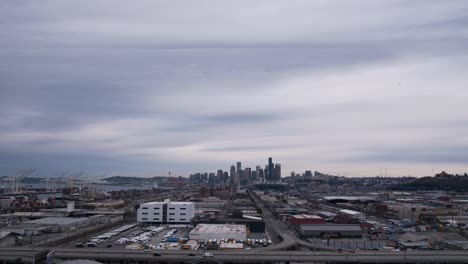 Hyperlapse-Aus-Der-Luft-Auf-Die-Skyline-Von-Seattle,-Sanfte-Dunkle-Wolken-Wogen,-Der-Verkehr-Rauscht-Vorbei