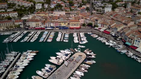 Drone-dolley-tilt-shot-of-a-boat-entering-the-large-harbour-in-Cassis-in-France