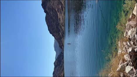 Toma-Vertical-De-Kayak-En-El-Río-Colorado-Con-Montañas-Al-Fondo.