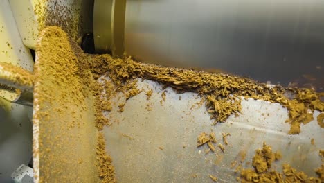 Close-up-slow-motion-of-chocolate-falling-from-roll-cylinder-machine-during-the-refining-process,-Malaysia