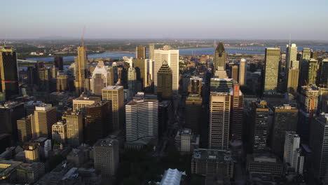 Drone-shot-tilting-toward-the-cityscape-of-downtown-Montreal,-sunset-in-Canada
