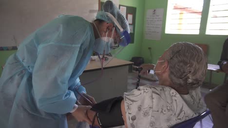 Ein-Arzt-In-Einer-Armen-Gemeinde-Untersucht-Eine-ältere-Frau-Mit-Einem-Blutdruckmessgerät-Und-Einem-Stethoskop