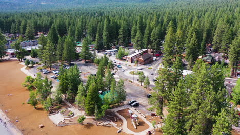 Aerial-view-over-a-beach-and-traffic-at-a-roundabout-in-Lake-Tahoe,-in-sunny-USA
